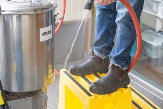 Blundstone CSA 162 stout brown boots worn by a person using a hose.