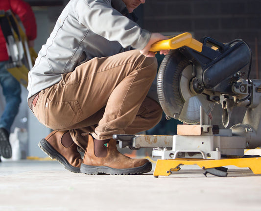 Blundstone CSA steel toed boot 164 in saddle brown, worn on a person using a saw.